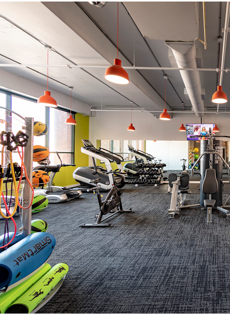 A gym with exercise equipment and a TV.