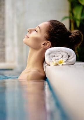woman resting head on towel inside pool