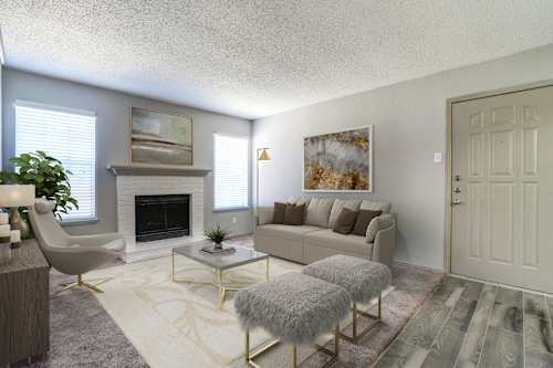 A living room with a fireplace, a couch, and a chair.