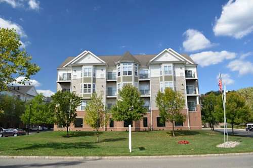 A large apartment building with a flag on the right side.