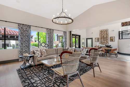 A living room with a large sofa and a chandelier.