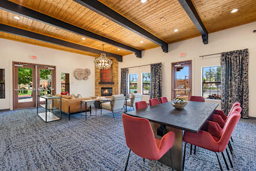 A dining room with a large table and chairs.