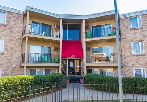 an apartment building with a red awning on the front