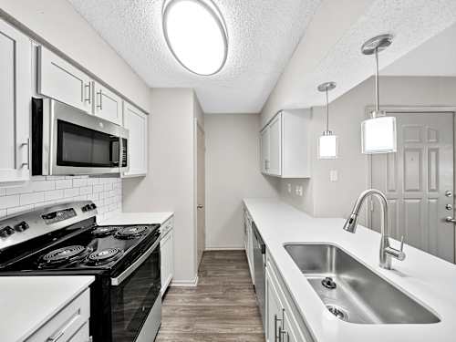 A kitchen with black and white appliances and cabinets.