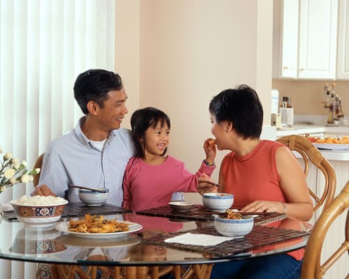 a family sitting at a table eating food