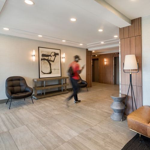 lobby with seating areas and man walking to the elevator