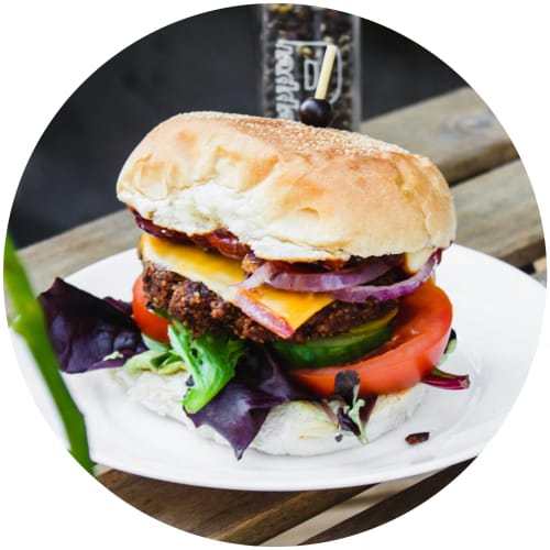 a sandwich on a white plate on a wooden table