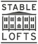 A black and white image of a building with the words "Stable Lofts" written above it.
