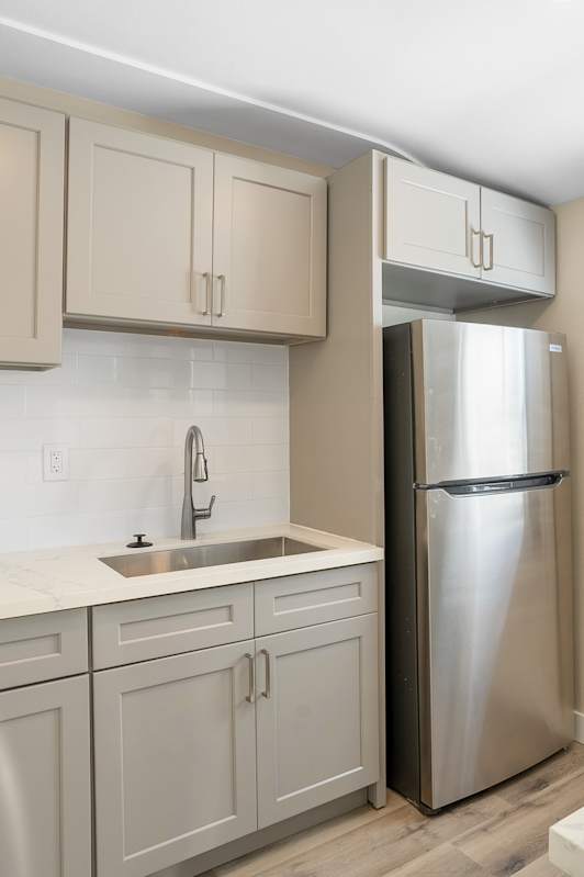 A modern kitchen with white cabinets and stainless steel appliances.