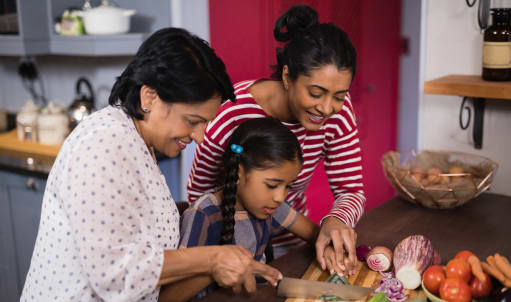 a family in the kitchen preparing food together