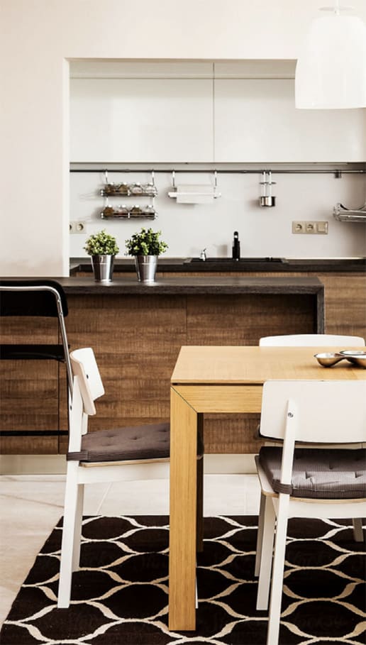 a kitchen with white walls and a wooden table and chairs