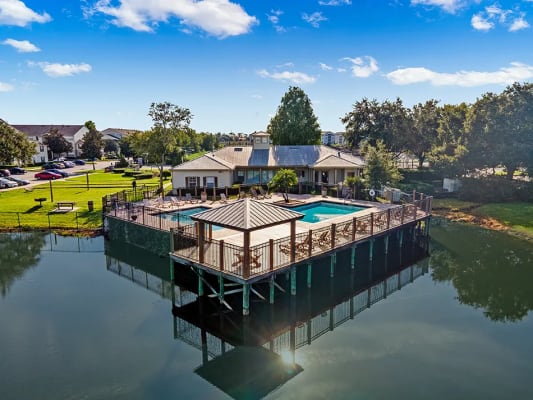 a dock with a pool and a house on a body of water
