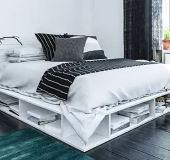 a bed with a white shelving unit under it