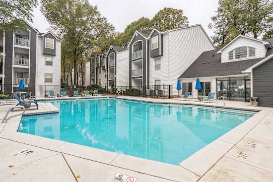 A swimming pool surrounded by apartment buildings.