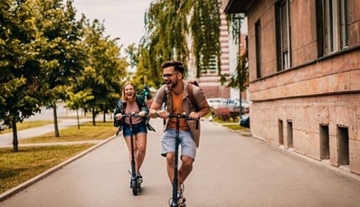 Couple on scooters on a city street
