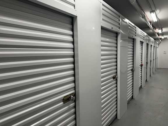 A long hallway with a series of closed storage units on either side.