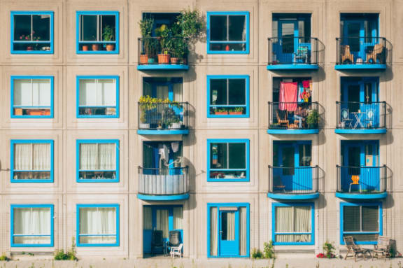 a building with blue doors and balconies on it