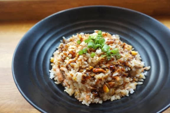 a bowl of rice with vegetables on a blue plate