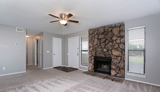 apartment with fireplace and ceiling fan at ponderosa apartments