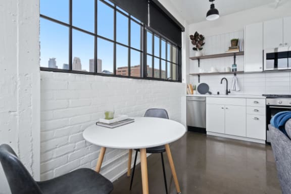 a kitchen with a white table and chairs and a large window