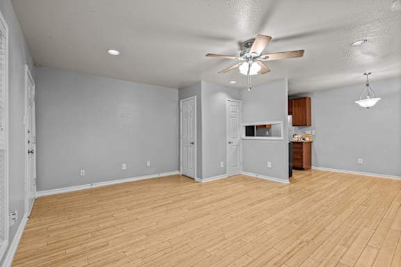 A room with a ceiling fan and wooden flooring.