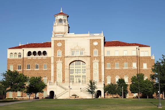 A large building with a clock tower and a red roof.