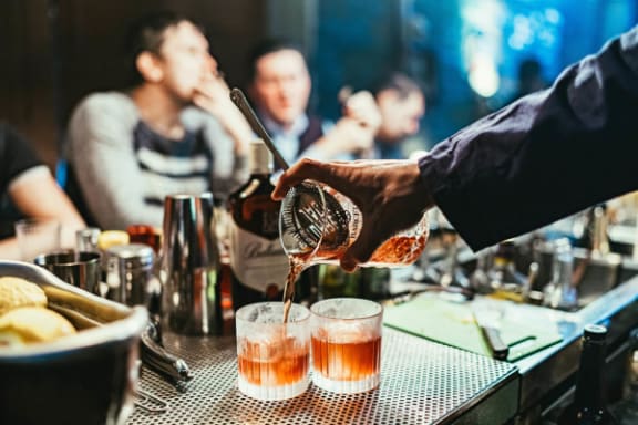 a bartender pouring beer into glasses at a bar