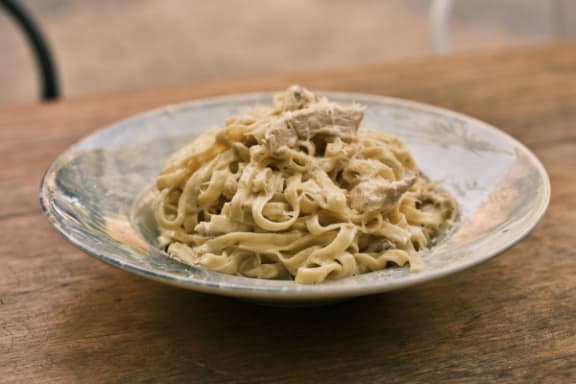 a bowl of pasta on a wooden table