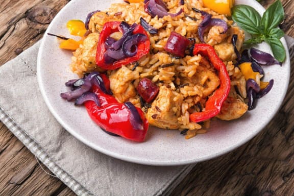 a plate of food with rice and chicken and peppers