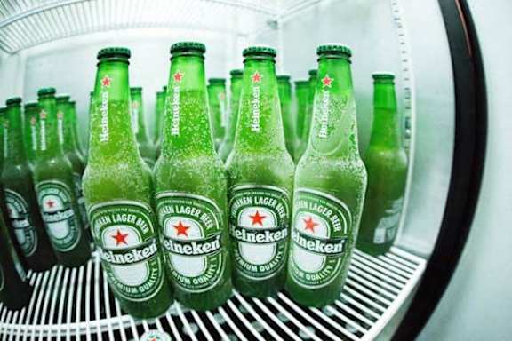 a row of green bottles of beer in a refrigerator