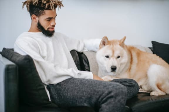 a man sitting on a couch with his dog