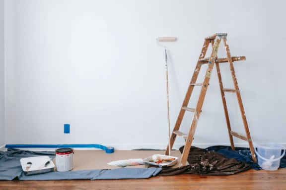 a room being remodeled with a ladder and supplies on the floor