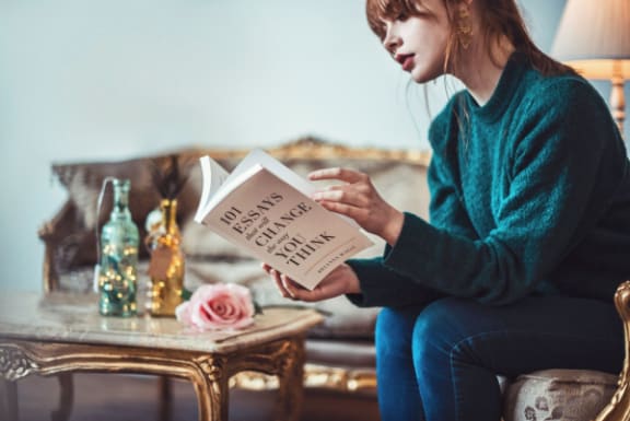 a woman sitting on a couch reading a book