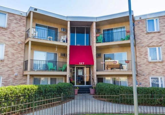 a multi-story residential building with a red awning