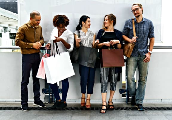 a group of people standing in an airport with their shopping bags