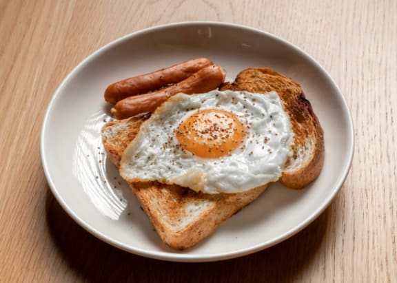 a plate with toast and fried eggs and sausage on it