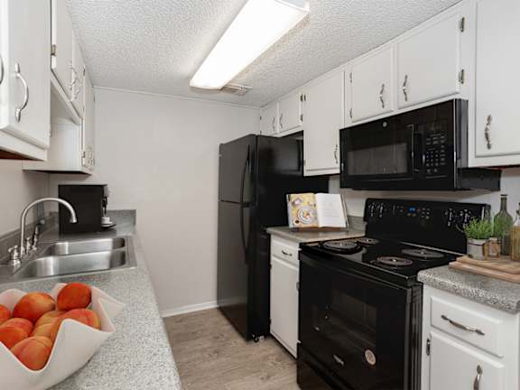 a kitchen with black appliances and white cabinets