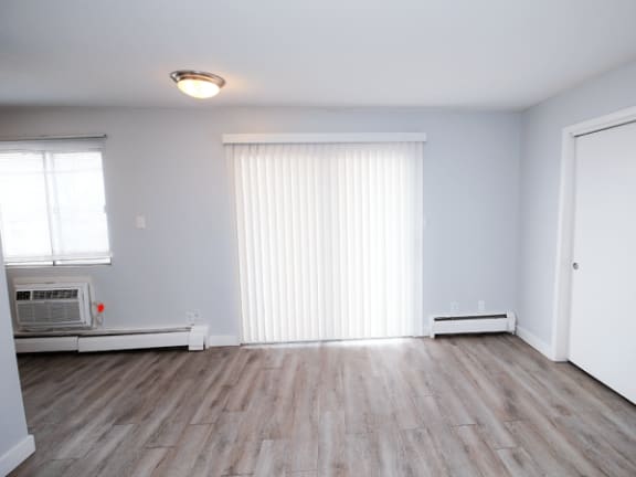 an empty living room with white walls and wood floors