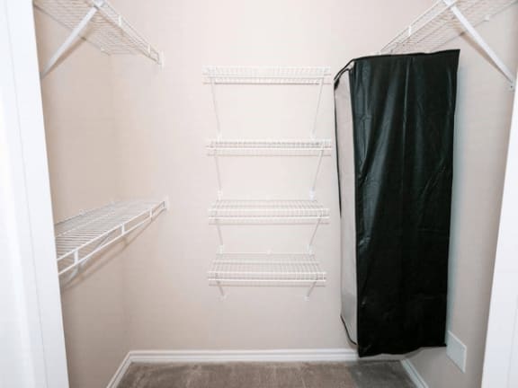 a walk in closet with shelves