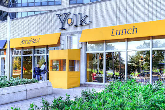 A yellow building with the word Yolk on it.
