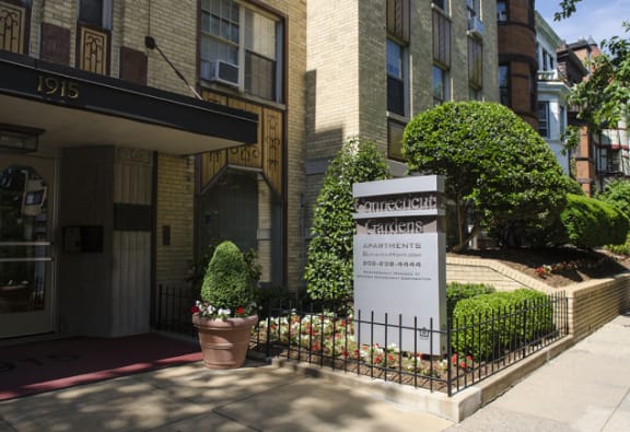 an apartment building with a sign in front of a gate