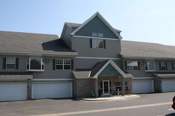 A large house with a grey roof and a white garage door.