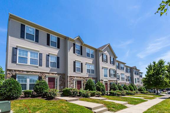 A row of townhouses with green bushes in front.