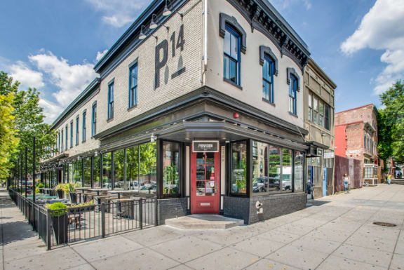 the front of a building with a red door on a sidewalk