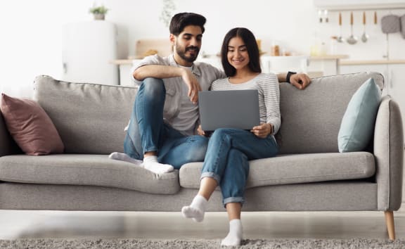 Young couple on couch with computer