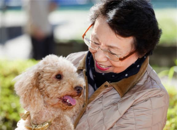 a woman holding a white dog in her arms
