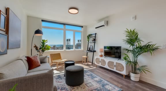 a living room with a couch and a tv and a window