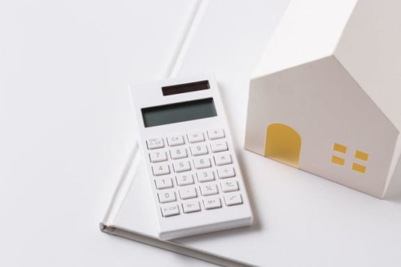 a calculator and a small house on a table