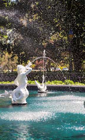A fountain with a statue of a bird in the middle of it.