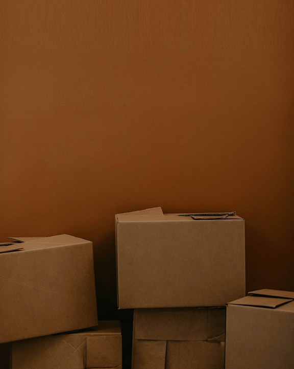 A stack of cardboard boxes with one standing upright.